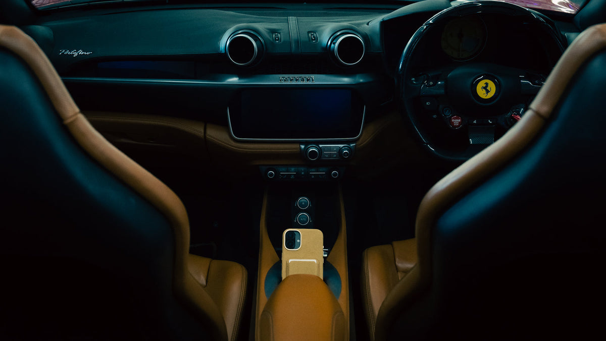 AURÊLO Dune Alcantara iPhone case photographed inside a Ferrari interior